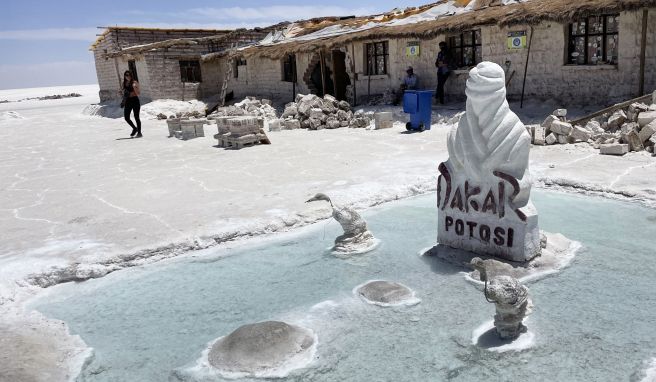 Das Salzhotel Playa Blanca liegt mitten in der Salar de Uyuni. Eine Stele erinnert daran, dass hier auch mal die Rallye Dakar Station machte.