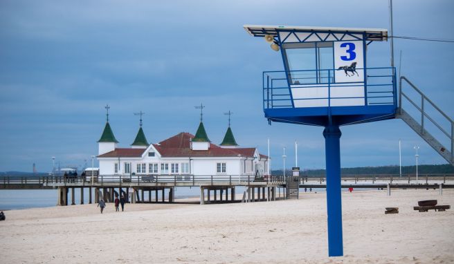 Spaziergänger sind am Strand der Insel Usedom unterwegs. Viele Hotels und Pensionen bieten im Nordosten bei einer Sonderaktion zur Nebensaison günstigere Zimmerpreise an.
