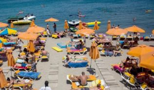 In Griechenland herrscht eine extreme Hitze. Einigen Touristen macht das nichts aus. Sie sonnen sich weiter. ##Foto: Santi Palacios/dpa In Griechenland herrscht eine extreme Hitze. Einigen Touristen macht das nichts aus. Sie sonnen sich weiter.