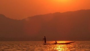 Sonnenaufgang am Inle-See - frühmorgens sind die Fischer schon auf dem Wasser. ##Foto: ICS Travel Group/dpa/tmn Sonnenaufgang am Inle-See - frühmorgens sind die Fischer schon auf dem Wasser.