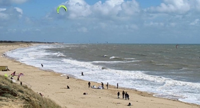 Starke Winde jagen Kitesurfer mit ihren Surfbrettern über die tosenden Wellen vor der Insel Ré.
