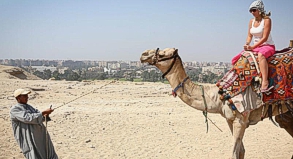 Urlauberin beim Kamelreiten: Die Unruhen in Kairo haben nach Einschätzung des Deutschen Reiseverbands bislang nicht die Touristenorte erreicht.
