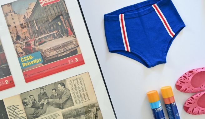 Eine Badehose vom VEB Strickwaren Oberlungwitz aus den 1970er Jahren, Badeschuhe «Carola» und Sonnenschutzspray «Violetta» sind in der Ausstellung «Grenzen der Freundschaft. Tourismus zwischen DDR, CSSR und Polen» im Dokumentationszentrum Alltagskultur der DDR zu sehen. 