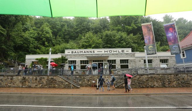 Besucher stehen am Eingang zur Baumannshöhle. Die Höhle wurde im 16. Jahrhundert entdeckt und gilt als die älteste und bekannteste Schauhöhle Deutschlands. 