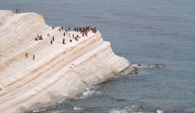 Menschen finden Komfort in der Meeresbrise auf der Scala dei Turchi, einer felsigen Klippe an der Küste von Realmonte im Süden Siziliens. 