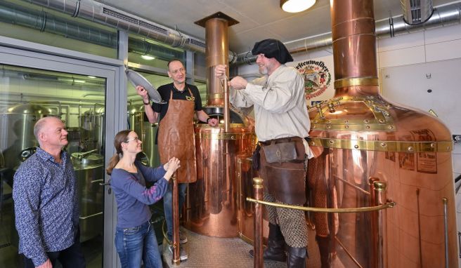 Am Sudkessel der Rathausbrauerei im alten Rathaus nehmen Holger Roger Pelz (l-r) von den Fürstenwalder Brau-Freunden und Katrin Riegel vom Tourismusverband zusammen mit Oliver Wittkopf und Bernd Norkeweit an einem Braukurs teil.