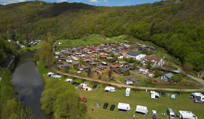 Zelte und Wohnmobile stehen auf dem Campingplatz Wiedhof am Ufer der Wied. Dahinter sind die Parzellen der Dauercamper zu sehen (Luftaufnahme mit einer Drohne).