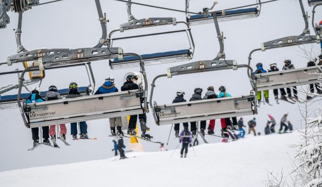 Skifahrer sitzen im Sessellift. Auch in Corona-Zeiten sind Spaziergänge, Rodeln und Skifahren im Sauer- und Siegerland sehr beliebt und mit wenigen Einschränkungen sehr gut möglich. 