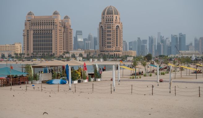 Strandleben in Doha: Baden im persischen Golf mit Blick auf die Skyline.