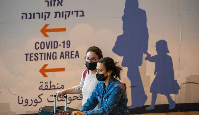 Reisende kommen am Ben-Gurion-Flughafen an. Um die Ausbreitung der neuen Omikron-Variante des Coronavirus einzudämmen, verlängert Israel das Einreiseverbot für Touristen um zehn Tage. 