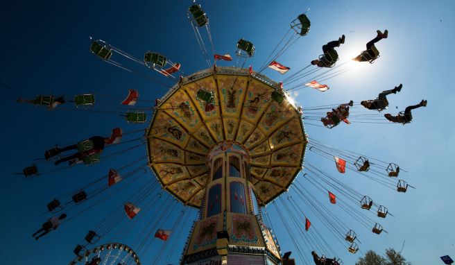 Kinder sitzen bei einer Karussellfahrt wegen der geringeren Fliehkraft nahe der Drehachse auf den inneren Plätzen sicherer.