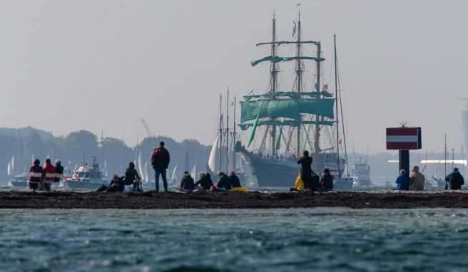 Zuschauer beobachten am Falkensteiner Strand die Windjammer-Parade der Kieler Woche. Die Stadt rechnet zum Sommerfest vom 18. bis 26. Juni mit einem Millionen-Publikum. 