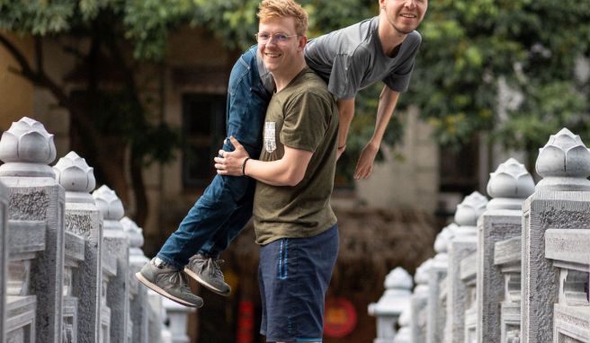 Lovis  Wiefelschütz trägt seinen Freund Alexander Källner über der Schulter auf einer Brücke in Vietnam.
