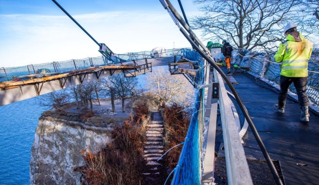 Auf der zukünftigen Besucherbrücke Königsweg wird die Absenkung des Rundwegs über dem Kreidefelsen «Königsstuhl» vorbereitet. Ab dem Frühjahr 2023 könnte die an einem Mast über dem 118 Meter hohen Königsstuhl schwebende Konstruktion für Besucher eröffnet werden.
