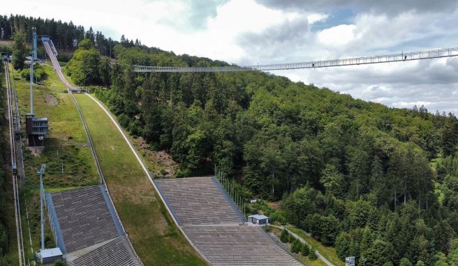 Alte und neue Attraktion nebeneinander: Der Skywalk führt von der Mühlenkopfschanze auf der einen Seite des Tals hinüber zum Musenberg auf der anderen Seite.