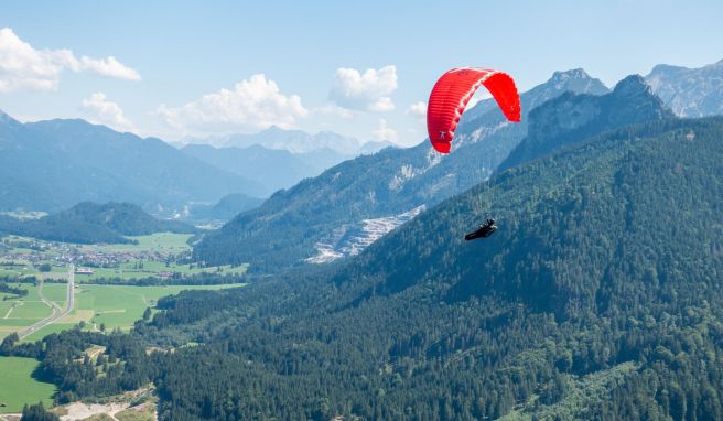 Verkehr am Himmel über Pfronten: Ein Solo-Paraglider fliegt neben dem Autoren und seinem Tandempiloten in Richtung Tal.