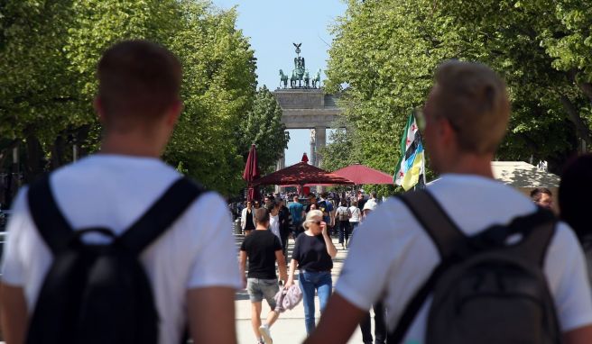 Touristen laufen auf der Straße «Unter den Linden» im Berlin. Die Tourismus-Branche verzeichnet wieder mehr Gäste und Übernachtungen. 