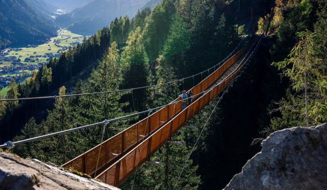 Wandern mit Aussicht: Die mehr als 100 Meter lange Hängebrücke im Stubaital führt an einem Berghang 46 Meter über den Boden und eröffnet einen Fernblick auf den Ort Neustift.