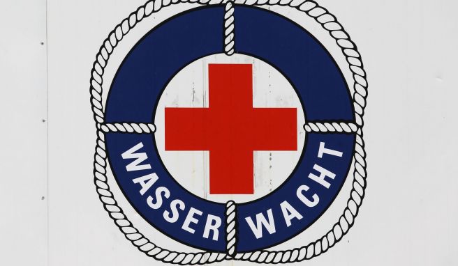 Das Logo der Wasserwacht des DRK an einem Rettungsturm im Ostseebad Warnemünde. Bis September halten die Rettungsschwimmer an bis zu zwölf Türmen Wache. 