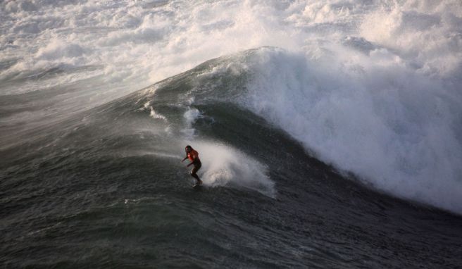 Big Wave! Surfer auf einer Welle an der Praia do Norte.