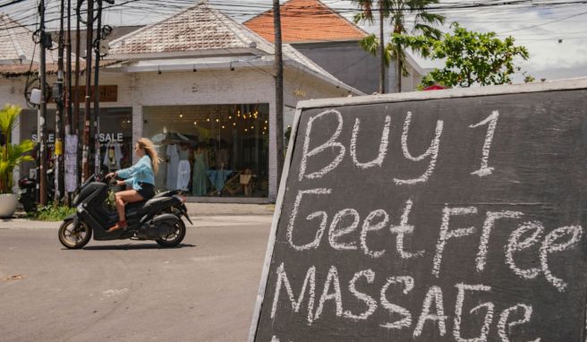 Eine Frau fährt ohne Helm auf einem Motorroller. Wegen zahlreicher Verstöße gehen indonesische Behörden inzwischen hart gegen Verkehrsverstöße vor.