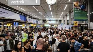 Fluggäste warten in der Abflughalle des Flughafens Schiphol Fluggäste warten in der Abflughalle des Flughafens Schiphol