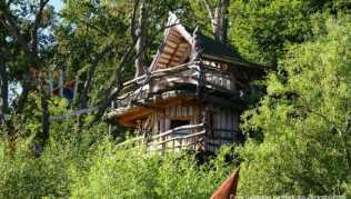Das Romantikbaumhaus ragt im Baumhaushotel Kriebelland zwischen den Bäumen hervor Das Romantikbaumhaus ragt im Baumhaushotel Kriebelland zwischen den Bäumen hervor