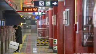 Ein Mann mit Mundschutz wartet an einer U-Bahn-Station auf einen Zug - China-Reisende müssen infolge des Coronavirus mit erheblichen Einschränkungen der Mobilität rechnen Ein Mann mit Mundschutz wartet an einer U-Bahn-Station auf einen Zug - China-Reisende müssen infolge des Coronavirus mit erheblichen Einschränkungen der Mobilität rechnen