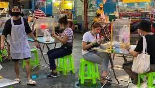 Das Leben in Chinatowns Garküchen ist zurück, wenn auch nur zwei Personen an einem Tisch sitzen dürfen, getrennt von einer Plexiglasscheibe Das Leben in Chinatowns Garküchen ist zurück, wenn auch nur zwei Personen an einem Tisch sitzen dürfen, getrennt von einer Plexiglasscheibe