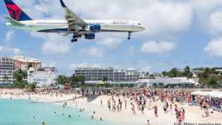 Flugzeug im Landeanflug über dem Maho Beach auf der Karibikinsel St. Martin - der Tourismus mit seinen Flugreisen trägt selbst zum Klimawandel bei Flugzeug im Landeanflug über dem Maho Beach auf der Karibikinsel St. Martin - der Tourismus mit seinen Flugreisen trägt selbst zum Klimawandel bei
