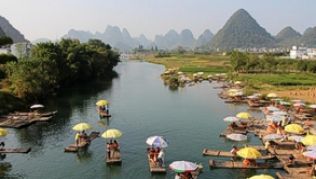 Bunte Sonnenschirme wie Farbtupfer in der Landschaft: Die Flößer bieten ihren Gästen etwas Schatten und laden zu einer gemächlichen Fahrt auf dem Fluss ein##Foto: Alexandra Frank Bunte Sonnenschirme wie Farbtupfer in der Landschaft: Die Flößer bieten ihren Gästen etwas Schatten und laden zu einer gemächlichen Fahrt auf dem Fluss ein
