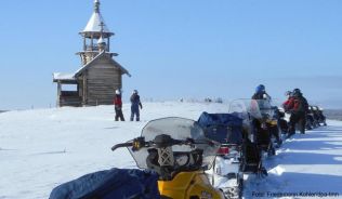 Halt am Unesco-Welterbe: Eine Gruppe von Motorschlittenfahrern macht Rast an einer der zahlreichen Holzkirchen auf der Insel Kischi im Onegasee. Halt am Unesco-Welterbe: Eine Gruppe von Motorschlittenfahrern macht Rast an einer der zahlreichen Holzkirchen auf der Insel Kischi im Onegasee