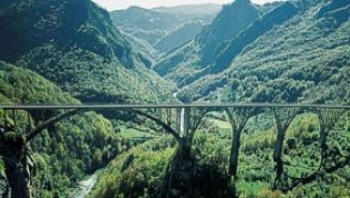 Kurz hinter Splaviste spannen sich die filigranen Bögen der Tara-Brücke über den Canyon.##Foto: Nationale Tourismusorganisation Montenegro/dpa/tmn Kurz hinter Splaviste spannen sich die filigranen Bögen der Tara-Brücke über den Canyon