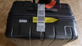 Eine konventionelle Gepäckbanderole an einem Rollenkoffer. Fluggesellschaften wollen Gepäckstücke künftig in der Banderole mit einem über Funkwellen lesbaren RFID-Chip versehen Eine konventionelle Gepäckbanderole an einem Rollenkoffer. Fluggesellschaften wollen Gepäckstücke künftig in der Banderole mit einem über Funkwellen lesbaren RFID-Chip versehen