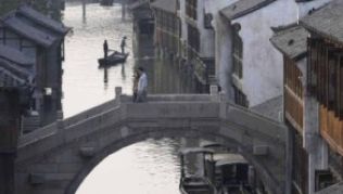 Besucher und Bewohner spazieren über rund 70 Brücken durch die Wasserstadt Wuzhen in China.##Foto: ChinaTours/dpa/tmn