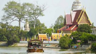Gemütlich tuckert eine ehemalige Reisbarke auf dem Chao Phraya an der Tempelanlage Wat Phuttaisawan südlich der Altstadt von Ayutthaya vorbei Gemütlich tuckert eine ehemalige Reisbarke auf dem Chao Phraya an der Tempelanlage Wat Phuttaisawan südlich der Altstadt von Ayutthaya vorbei
