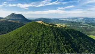 Der Blick auf grüne Vulkankegel begeistert Wanderer auf dem Weg zum Gipfel des Puy de Dôme (im Hintergrund)##Foto: Francis Cormon/Auvergne-Rhônes-Alpes Tourisme/dpa-tmn Der Blick auf grüne Vulkankegel begeistert Wanderer auf dem Weg zum Gipfel des Puy de Dôme (im Hintergrund)