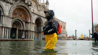Eine Passantin bahnt sich ihren Weg durch den überfluteten Markusplatz. Starke Regenfälle haben in Venedig Teile der Stadt überflutet Eine Passantin bahnt sich ihren Weg durch den überfluteten Markusplatz. Starke Regenfälle haben in Venedig Teile der Stadt überflutet