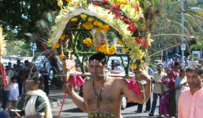 Die Teilnehmer der Hindu Parade haben schwer zu tragen.