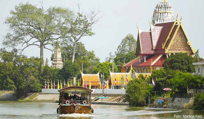Gemütlich tuckert eine ehemalige Reisbarke auf dem Chao Phraya an der Tempelanlage Wat Phuttaisawan südlich der Altstadt von Ayutthaya vorbei Gemütlich tuckert eine ehemalige Reisbarke auf dem Chao Phraya an der Tempelanlage Wat Phuttaisawan südlich der Altstadt von Ayutthaya vorbei