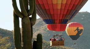 Lautlos hebt sich der Heißluftballon über die Wüste von Arizona. Typisch für die Gegend sind die Saguaro-Kakteen