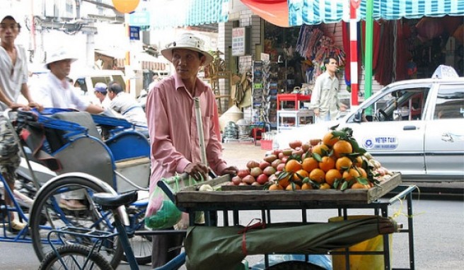 Ein Fruchtverkäufer im alltäglichen Getümmel.