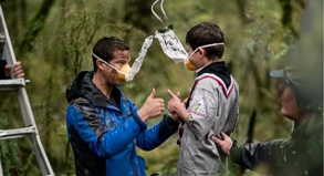 So geht es richtig: Der britische Abenteurer Bear Grylls (l) zeigt drei jungen Pfadfindern, wie sie die Sauerstoffmasken benutzen müssen.##Foto: Air New Zealand So geht es richtig: Der britische Abenteurer Bear Grylls (l) zeigt drei jungen Pfadfindern, wie sie die Sauerstoffmasken benutzen müssen.
