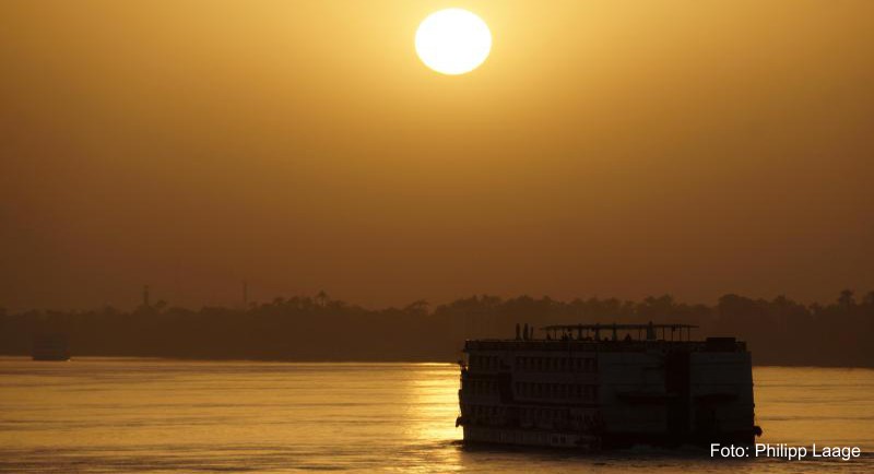 Ein Kreuzfahrtschiff gleitet in der Abendsonne auf den Nil