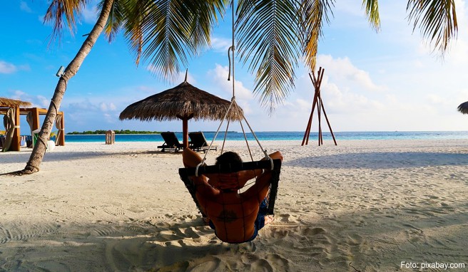 Weißer Sand auf der Haut, in der Hand ein exotischer Drink und dazu das sanfte Rollen des Meeres