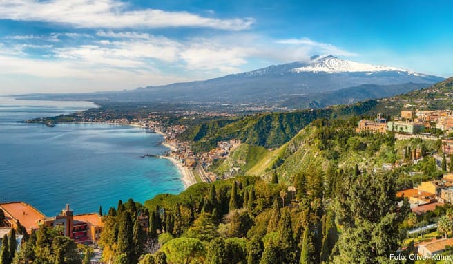 Blick auf Taormina, den Nachbarort Giardini-Naxos und die Küste. Im Hintergrund der imposante, im Frühjahr oft noch schneebedeckte Ätna