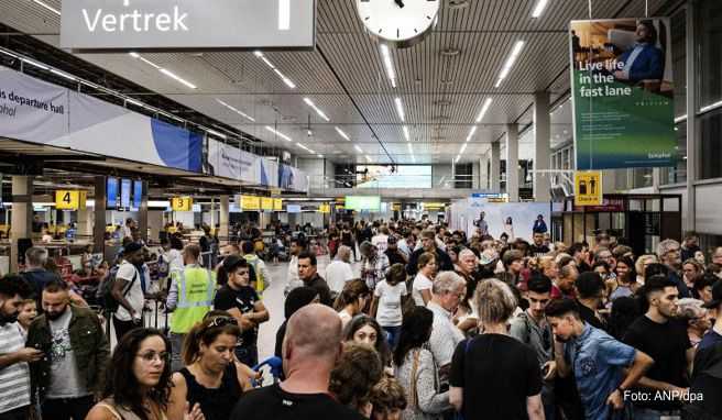 Fluggäste warten in der Abflughalle des Flughafens Schiphol