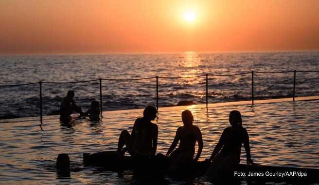 Schwimmer verfolgen den Sonnenaufgang am Bronte Beach Pool vom Ocean-Pool aus. Das Schwimmen und Baden in Meerwasser-Pools hat in Australien Tradition Schwimmer verfolgen den Sonnenaufgang am Bronte Beach Pool vom Ocean-Pool aus. Das Schwimmen und Baden in Meerwasser Pools hat in Australien Tradition