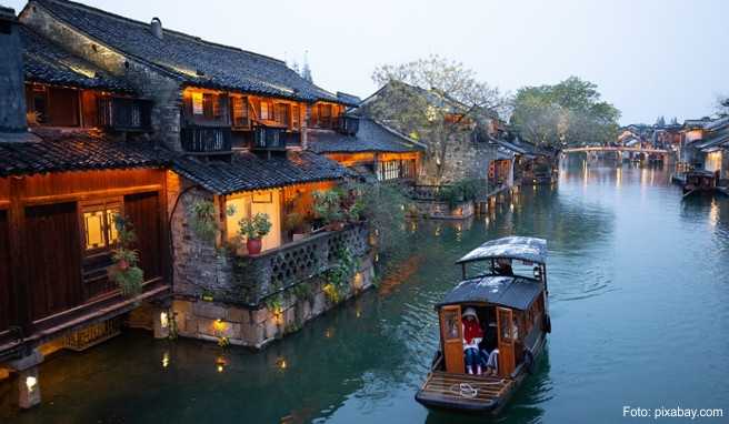 Besucher und Bewohner spazieren über rund 70 Brücken durch die Wasserstadt Wuzhen in China