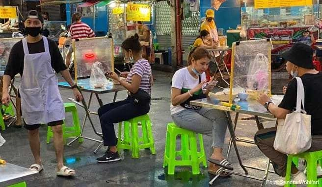 Das Leben in Chinatowns Garküchen ist zurück, wenn auch nur zwei Personen an einem Tisch sitzen dürfen, getrennt von einer Plexiglasscheibe Das Leben in Chinatowns Garküchen ist zurück, wenn auch nur zwei Personen an einem Tisch sitzen dürfen, getrennt von einer Plexiglasscheibe